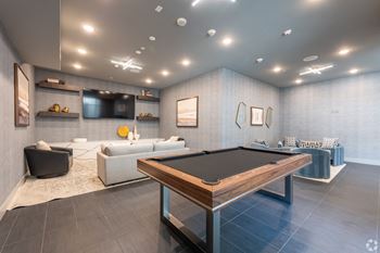 a game room with a pool table and couches at Aura Vegas Apartments, Nevada